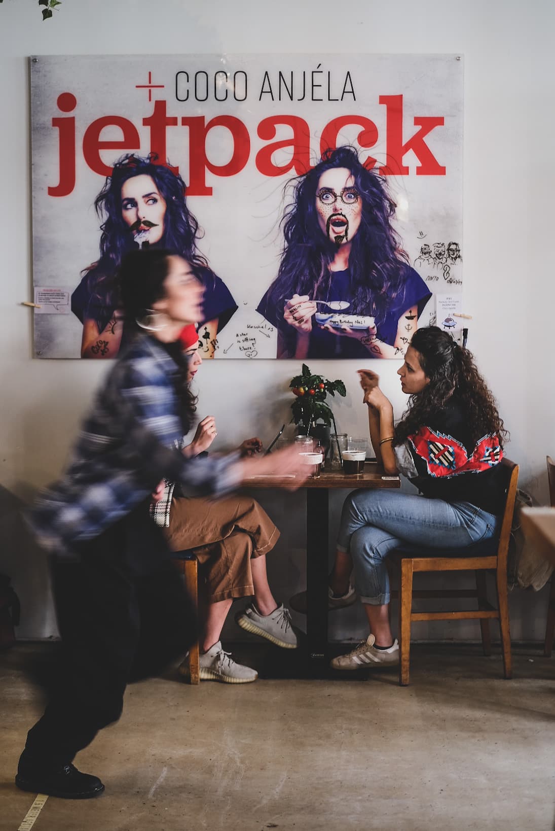 Blurred motion capture in front of the Coco Anjela Jetpack artwork during an event