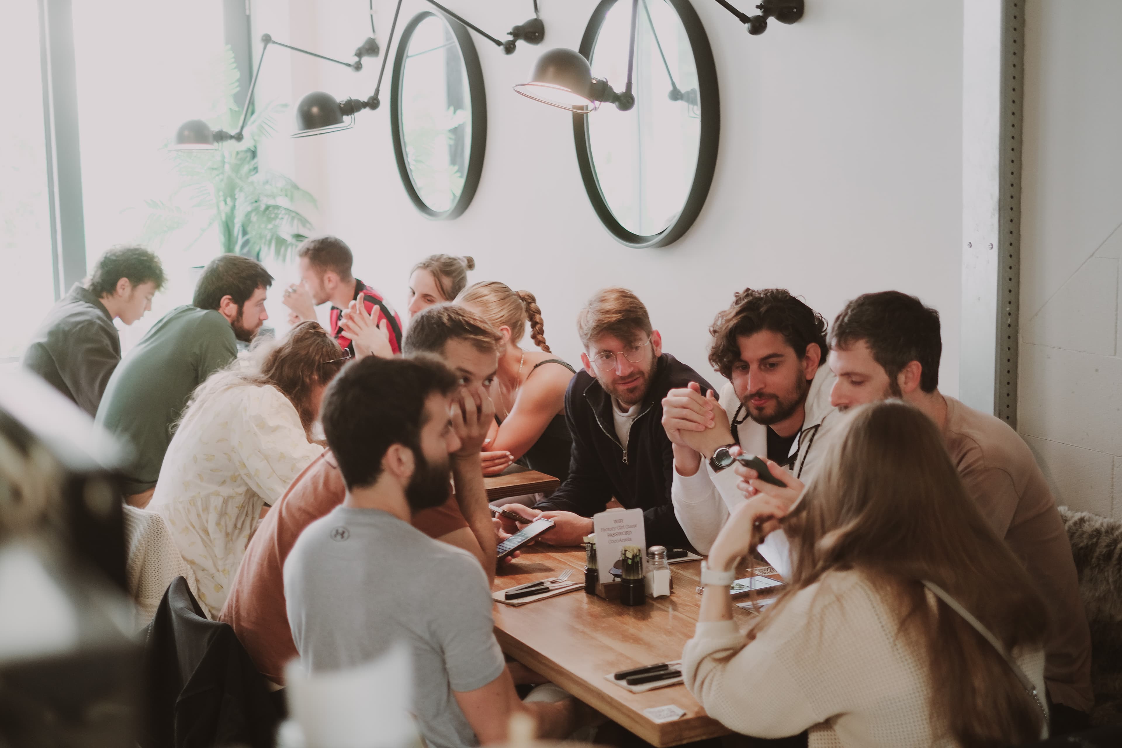Long-table group gathering in the dining room at Factory Girl