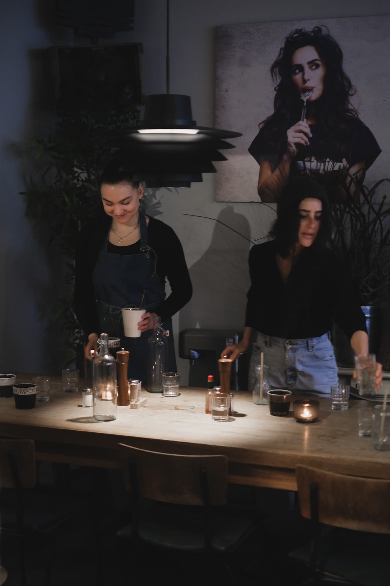 Private evening setup with two hosts preparing drinks at a softly lit Factory Girl table